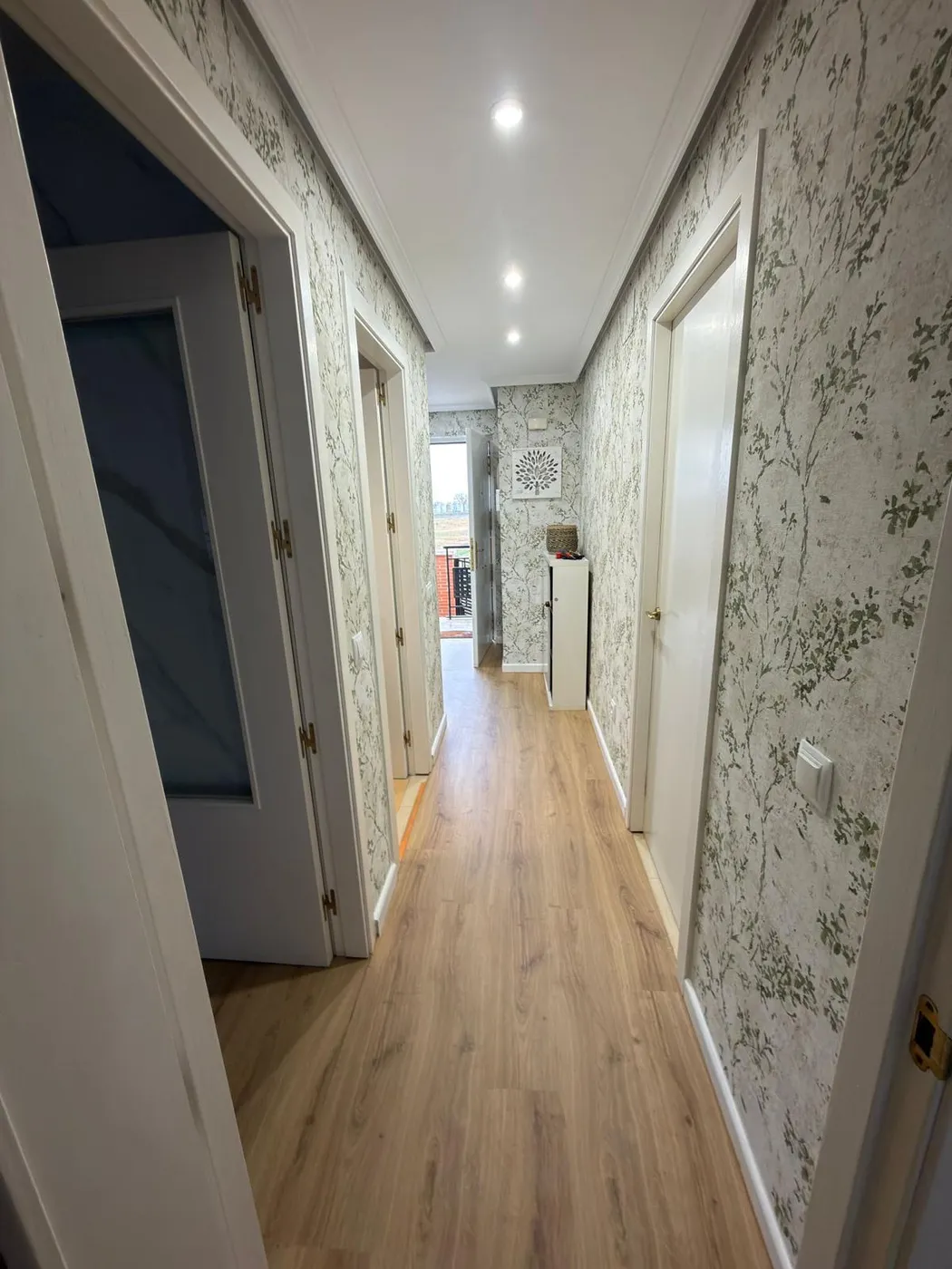 Comedor reformado con mesa, lámpara de ratán y espejo decorativo