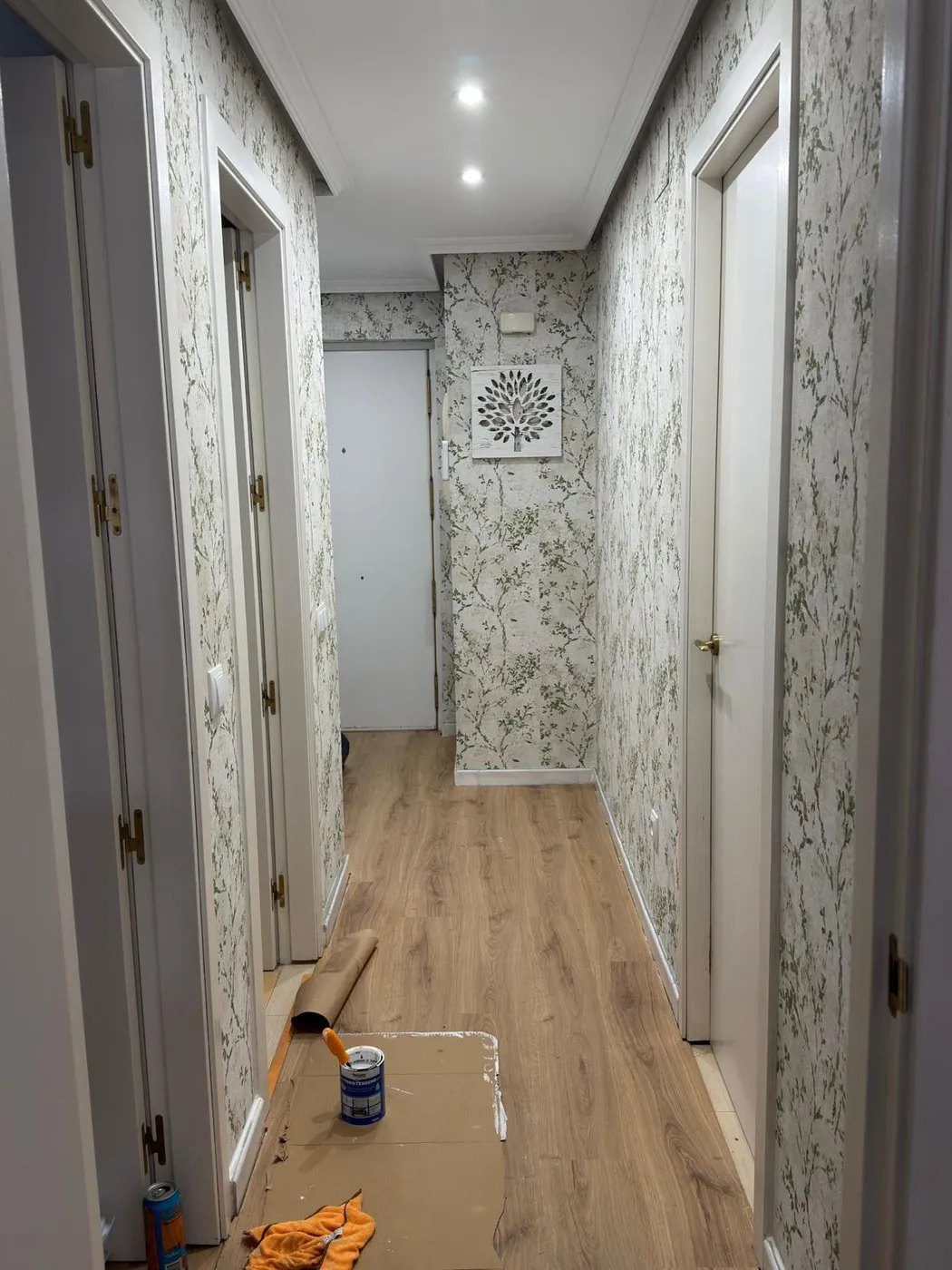 Salón reformado con sofá gris, iluminación cálida y decoración